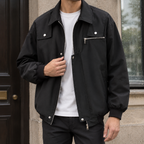 Man wearing a black utility jacket with silver hardware