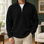 Man wearing a black ribbed quarter-zip jumper