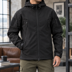 Man wearing a black tactical jacket with hood